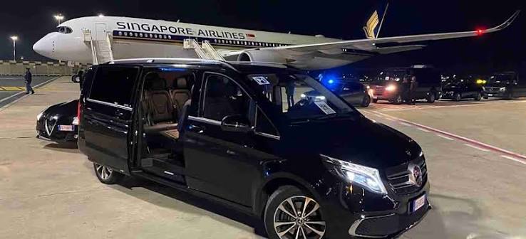 Black Mercedes-Benz V-Class waiting beside an aircraft at night