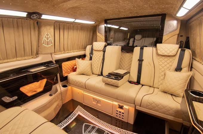 Cream leather VIP van interior with curtained windows and quilted seats